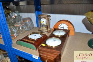 A clock barometer and three mantel clocks