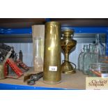 A brass shell case, fire irons and a brass oil lamp converted to electric