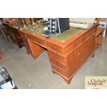 A twin pedestal desk with green leather inset