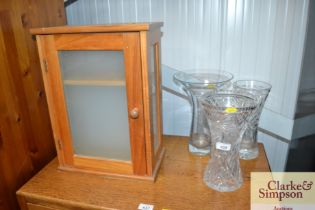 Three glass vases and a wooden wall cabinet