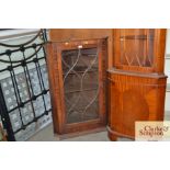 An antique corner cabinet with astral glazed door