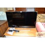 A Sony Bravia flat screen television with remote control