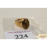 A yellow metal tigers eye set ring