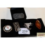 Five various white metal and amber brooches