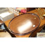 A mahogany oval tea tray with brass carrying handl