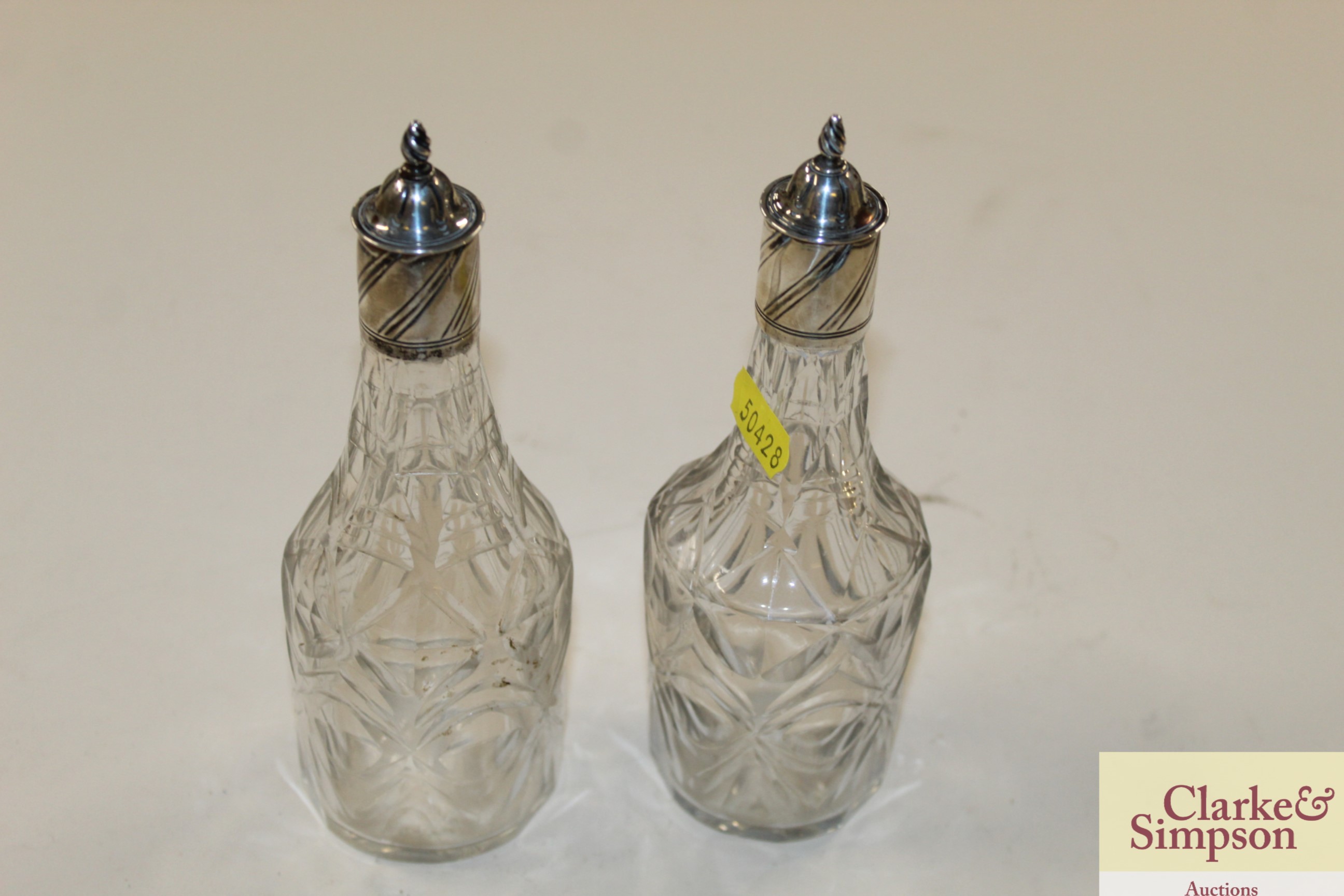 A pair of antique cut glass oil bottles with white
