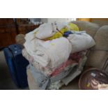 A large bundle of various blankets, throws etc.