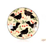 A large pottery charger decorated black birds and