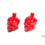 A pair of red glass skull shaped bottles, 18cm hig