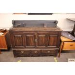 An oak sideboard, fitted raised panelled back, cup