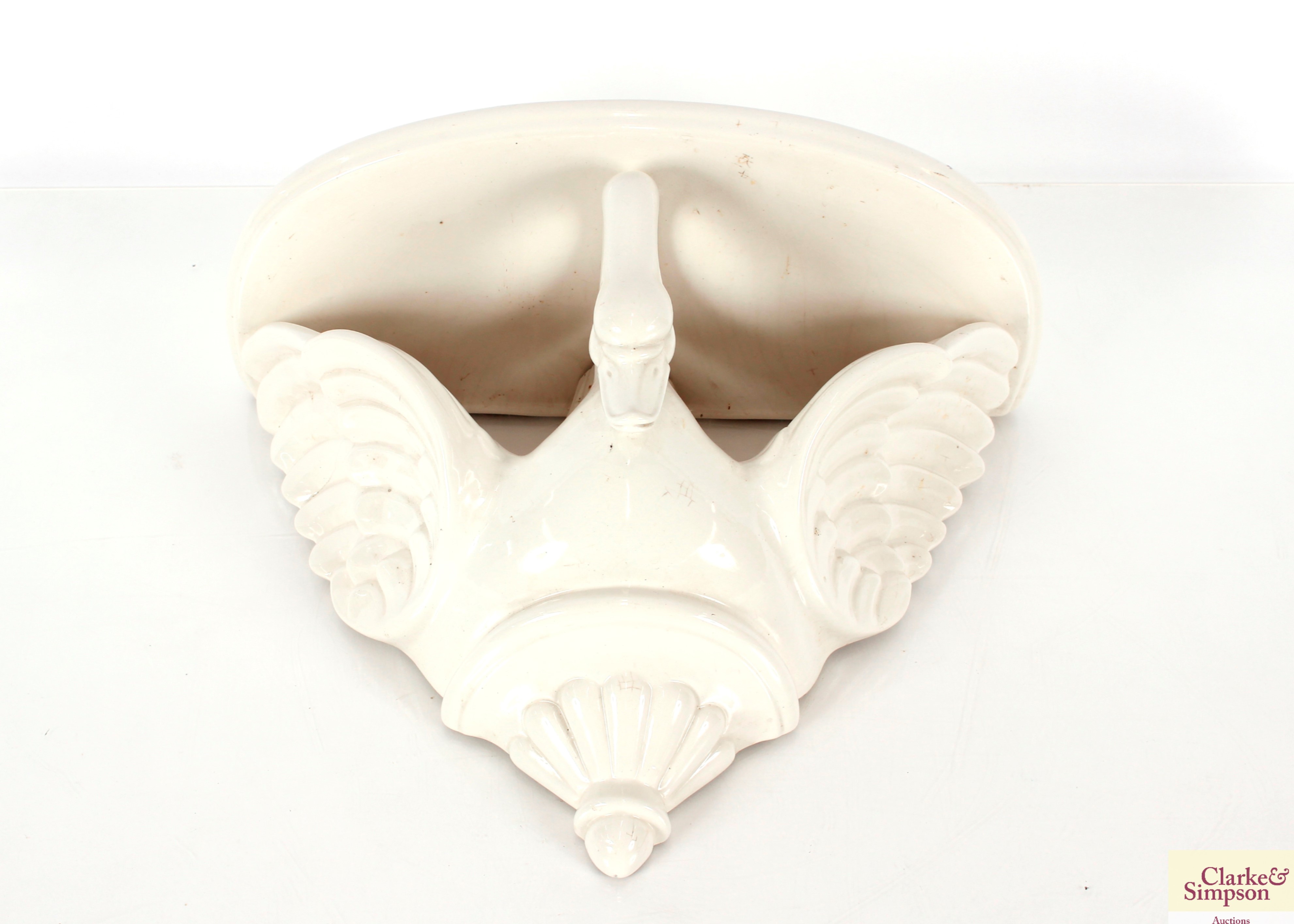 A white glazed pottery wall bracket, in the form o