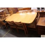 A teak effect extending dining table; and six ladd
