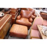 A brown leather deep seated east chair and matchin