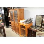 A pine glass display cabinet raised on cupboard ba