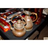 An antique copper water jug and a copper kettle