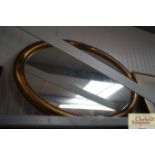 An oval gilt framed wall mirror