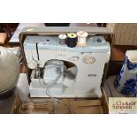 An Elna sewing machine in fitted case (sold as col