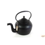 A large heavy cast iron kettle with loop handle