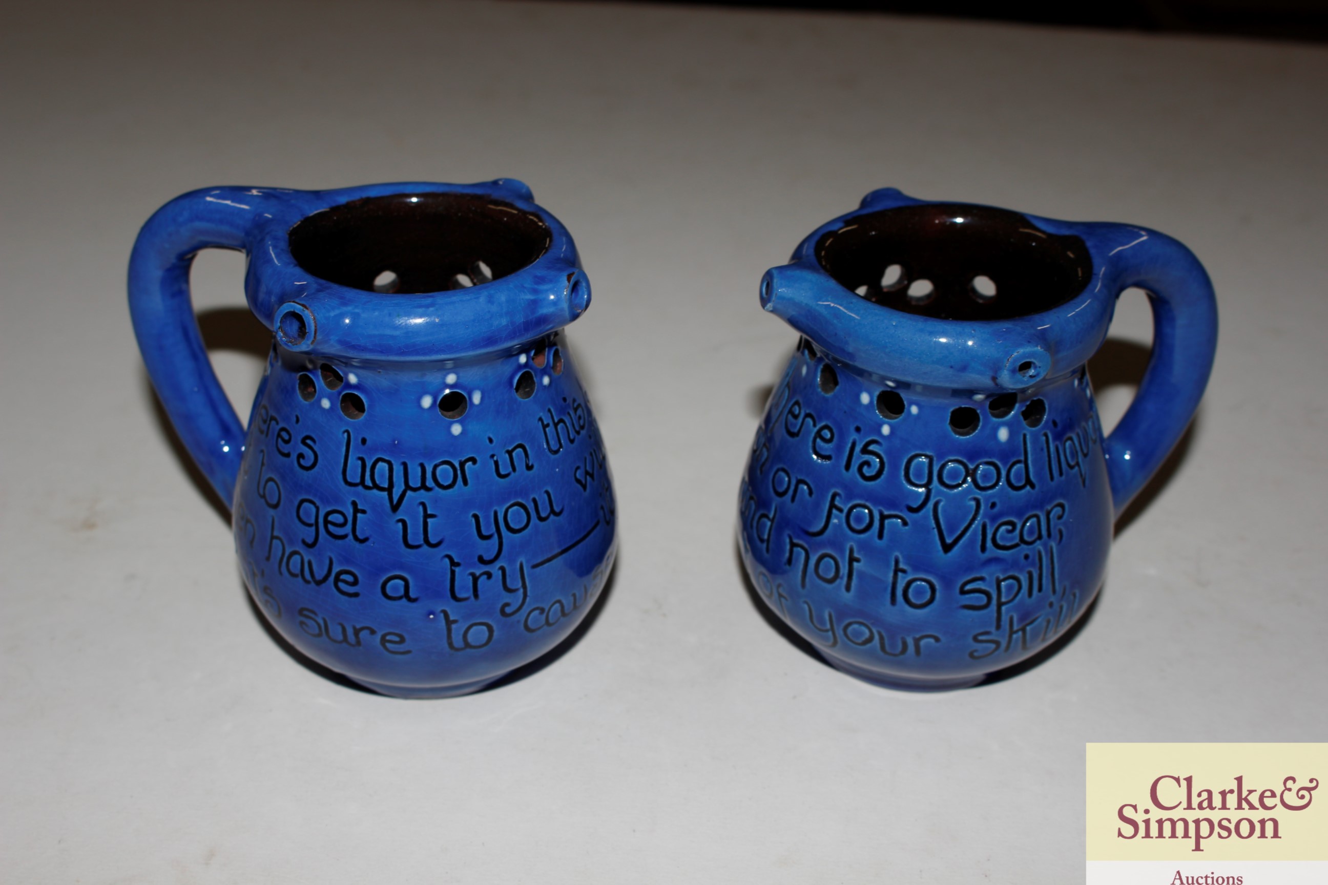 A pair of Branham pottery puzzle jugs