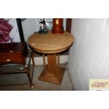 A circular pine pedestal table raised on bobbin tu