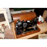 A Singer hand sewing machine in fitted case
