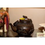 A Chinese bronze tea kettle of circular form with