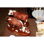 A Royal Doulton Hereford cow and calf; and a Heref