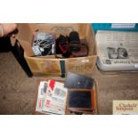 A box containing camera cases, camera manuals etc.