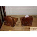 A pair of carved wooden bookends in the form of el