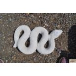 A concrete garden ornament in the form of a snake