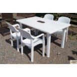 A white plastic garden table and four chairs