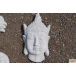 A garden wall plaque in the form of a Buddhas head