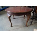 A circular coffee table raised on cabriole support