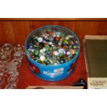 A tin containing a large quantity of marbles