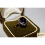 A 925 ring set amethyst coloured stone in green bo