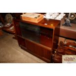 A teak bookcase enclosed by sliding doors