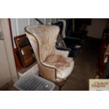 A wing armchair raised on bold carved cabriole sup