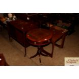 A mahogany drum shaped table with chequerboard top