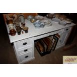 A white pedestal desk with central keyboard drawer