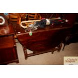 An antique oak gate leg table fitted single drawer