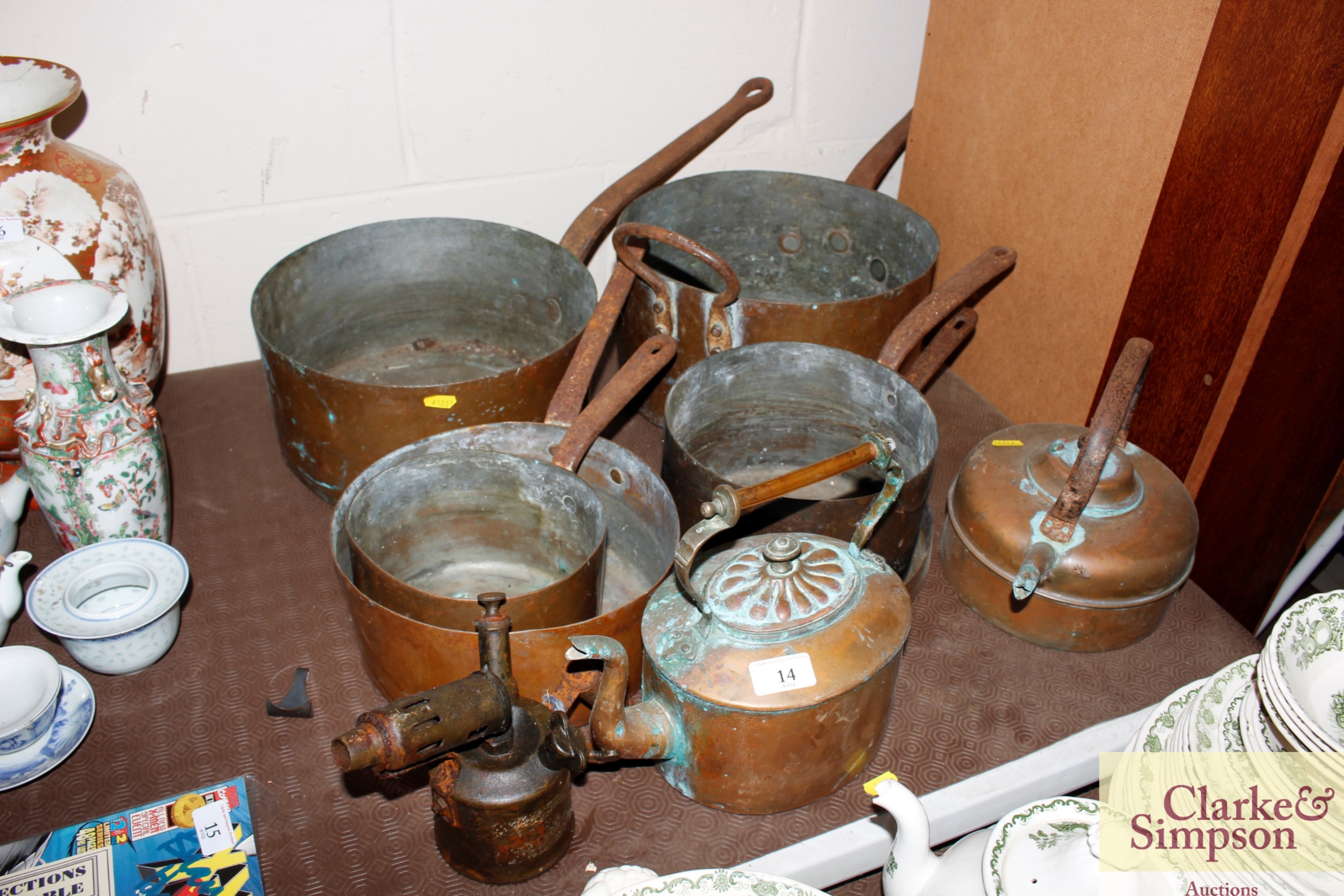 A collection of antique copper saucepans, kettle a