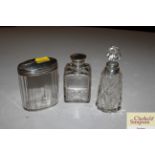 Two glass and silver mounted scent bottles; and a silver mounted tidy jar