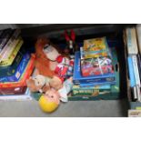 A box containing various games and stuffed toys et