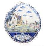 A large Dutch Delft polychrome plaque, painted with buildings, figures and bridge scene, 57cm x 49cm