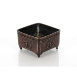 A Chinese bronze censer of square section, key decorated frieze and dragons below on short