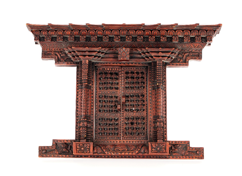 A late 19th Century Chinese carved wooden architectural frame, the pagoda type edge and twin opening