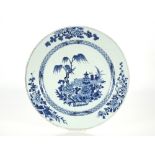 A large 19th Century Chinese blue and white charger, decorated with a central scene of objects on
