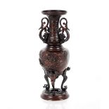 A Japanese Meiji period bronze vase, of baluster form flanked by dragon handles and birds below on