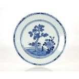 A large 19th Century Chinese blue and white charger, central scenes of trees in a garden, having