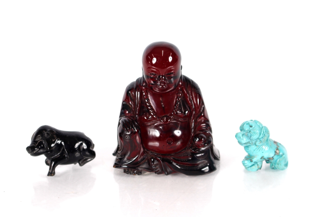 A Chinese cherry coloured amber type seated Buddha, holding fruit 6cm high; a  carved turquoise